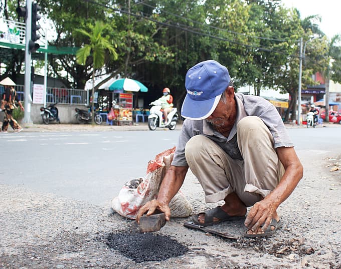 Instead of picking holes, a Mekong Delta elder fills them