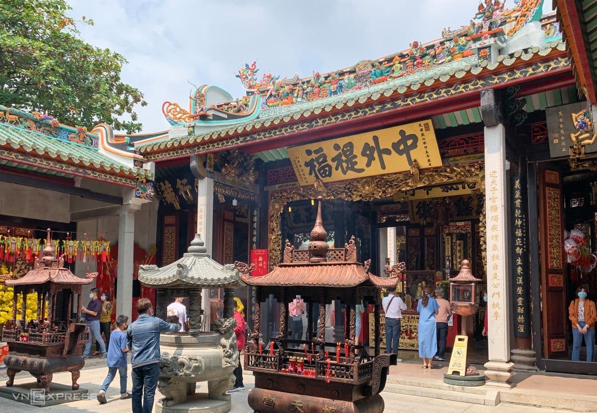 Crawling under a wooden horse for luck in Saigon pagoda